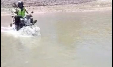 Bripka--I-Gede-Suta-Perdana,-Bantu-Siswa-Seberangi-Sungai-Tuasene-Kecil